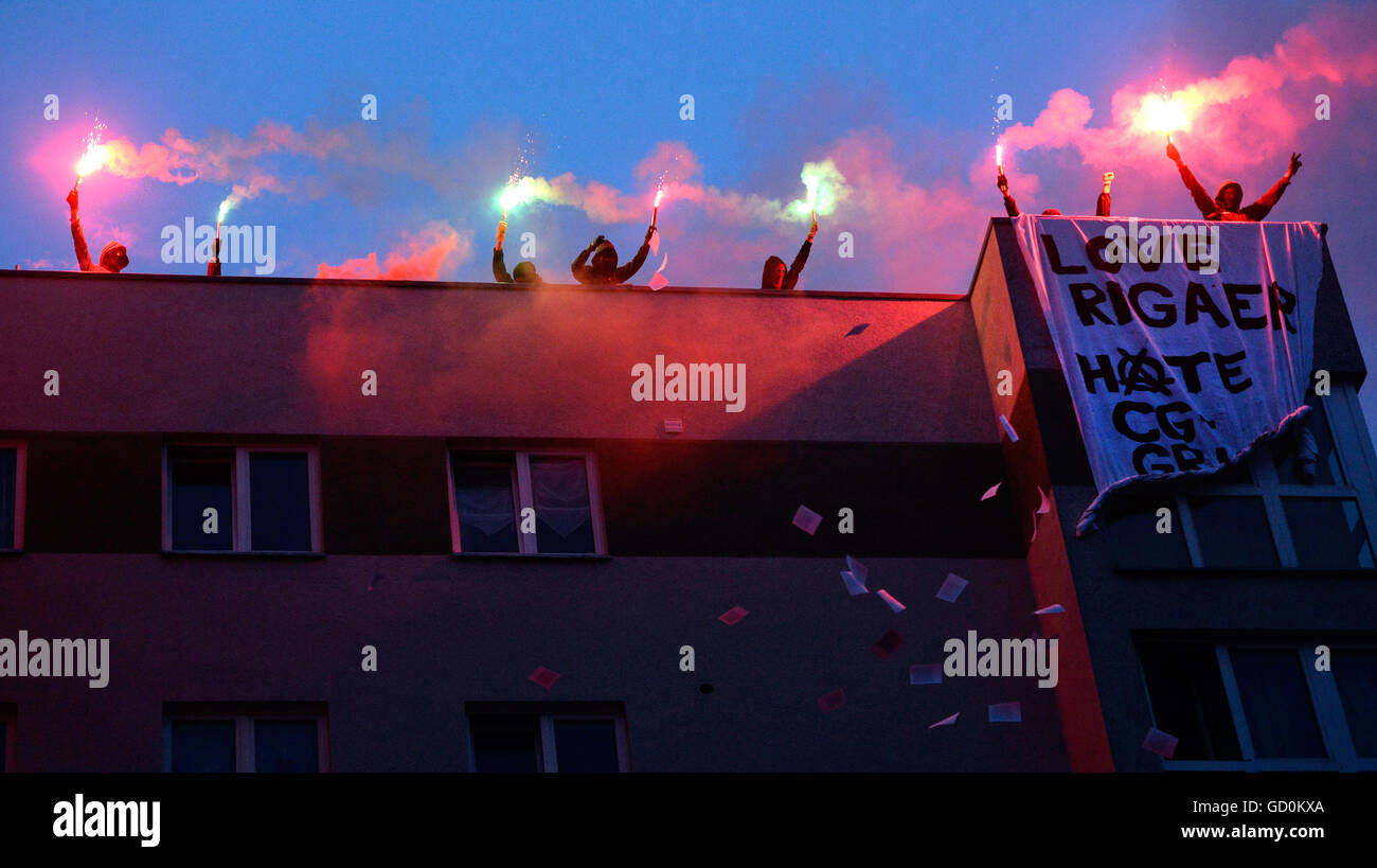 I residenti di Rigaer Strasse protestare con bengala incendi sul tetto di una casa di una dimostrazione da parte di sinistra dei gruppi contro una città per la trasformazione di sostenere quelle inhabitents autonomi di case in Rigaer Strasse, Berlino, Germania, 09 luglio 2016. Dopo le violenze di ala sinistra estrema violenza incluso auto incendio doloso nella Locazione per settimane, forze di polizia sono in azione in progetti di vita. Foto: Maurizio Gambarini/dpa Foto Stock