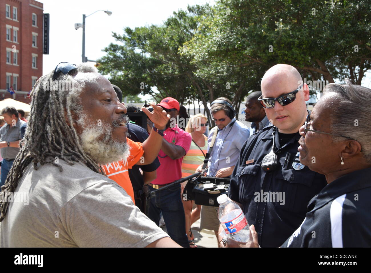Dallas, Texas, Stati Uniti d'America. 10 Luglio, 2016. Due americani Africani avente un leggermente riscaldato discussione davanti a Dallas funzionario di polizia a Dallas questura. Credito: Hum Immagini/Alamy Live News Foto Stock