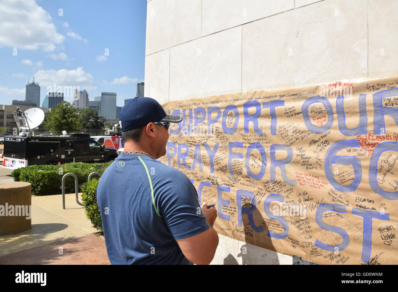 Dallas, Texas, Stati Uniti d'America. 10 Luglio, 2016. Area di Dallas residenti accorsi a Dallas Questura di domenica per offrire cordoglio per i caduti cinque funzionari di polizia. Questo uomo è scrivere una nota personale per gli ufficiali di polizia su un poster appeso a Dallas questura. Credito: Hum Immagini/Alamy Live News Foto Stock