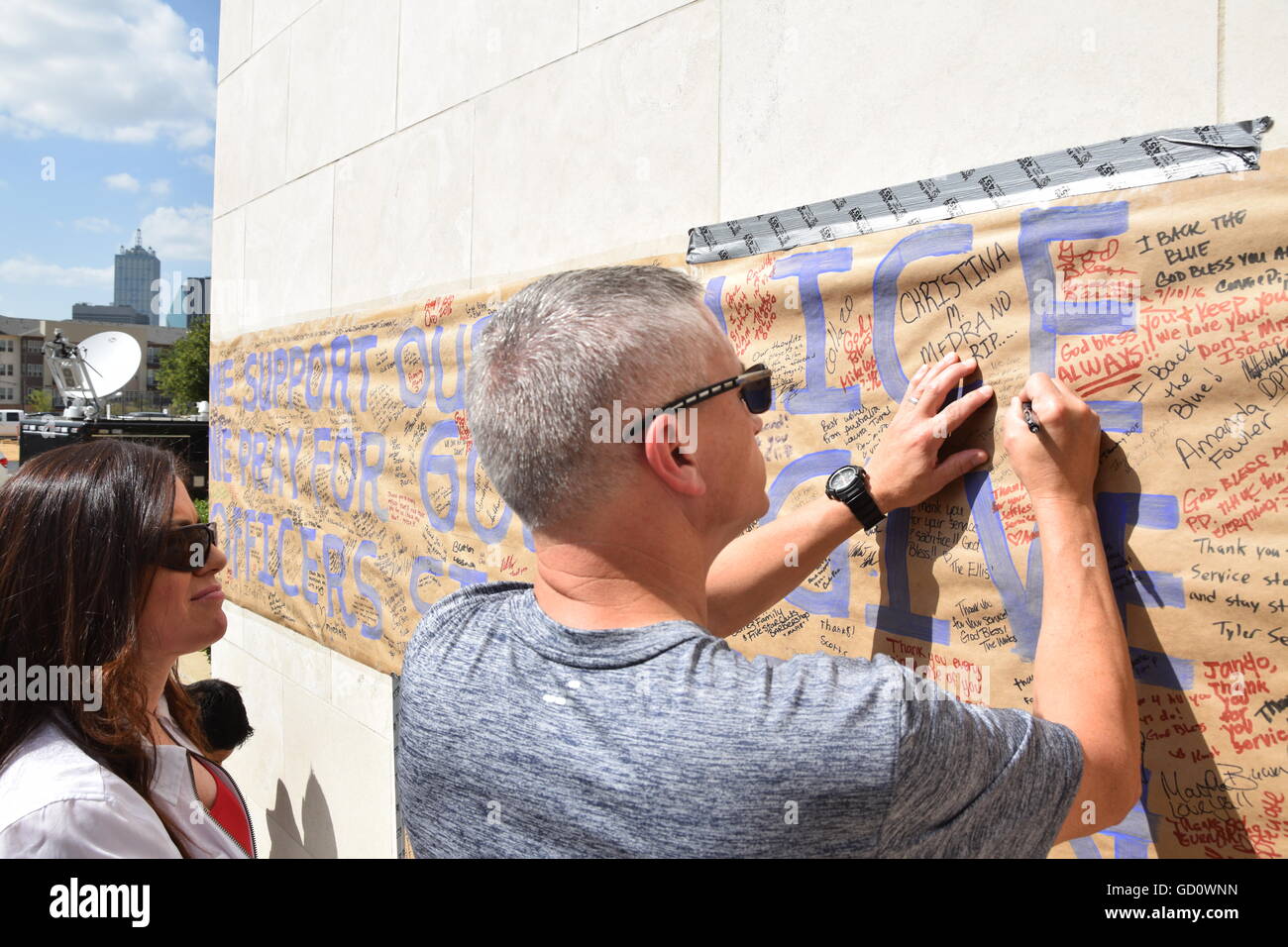 Dallas, Texas, Stati Uniti d'America. 10 Luglio, 2016. Area di Dallas residenti accorsi a Dallas Questura di domenica per offrire cordoglio per i caduti cinque funzionari di polizia. Questo uomo è scrivere una nota personale per gli ufficiali di polizia su un poster appeso a Dallas questura. Credito: Hum Immagini/Alamy Live News Foto Stock