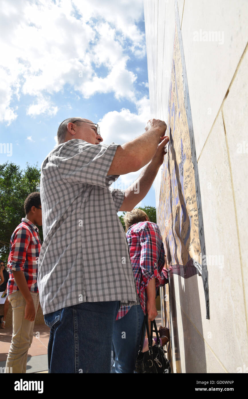 Dallas, Texas, Stati Uniti d'America. 10 Luglio, 2016. Area di Dallas residenti accorsi a Dallas Questura di domenica per offrire cordoglio per i caduti cinque funzionari di polizia. Questo uomo è scrivere una nota personale per gli ufficiali di polizia su un poster appeso a Dallas questura. Credito: Hum Immagini/Alamy Live News Foto Stock