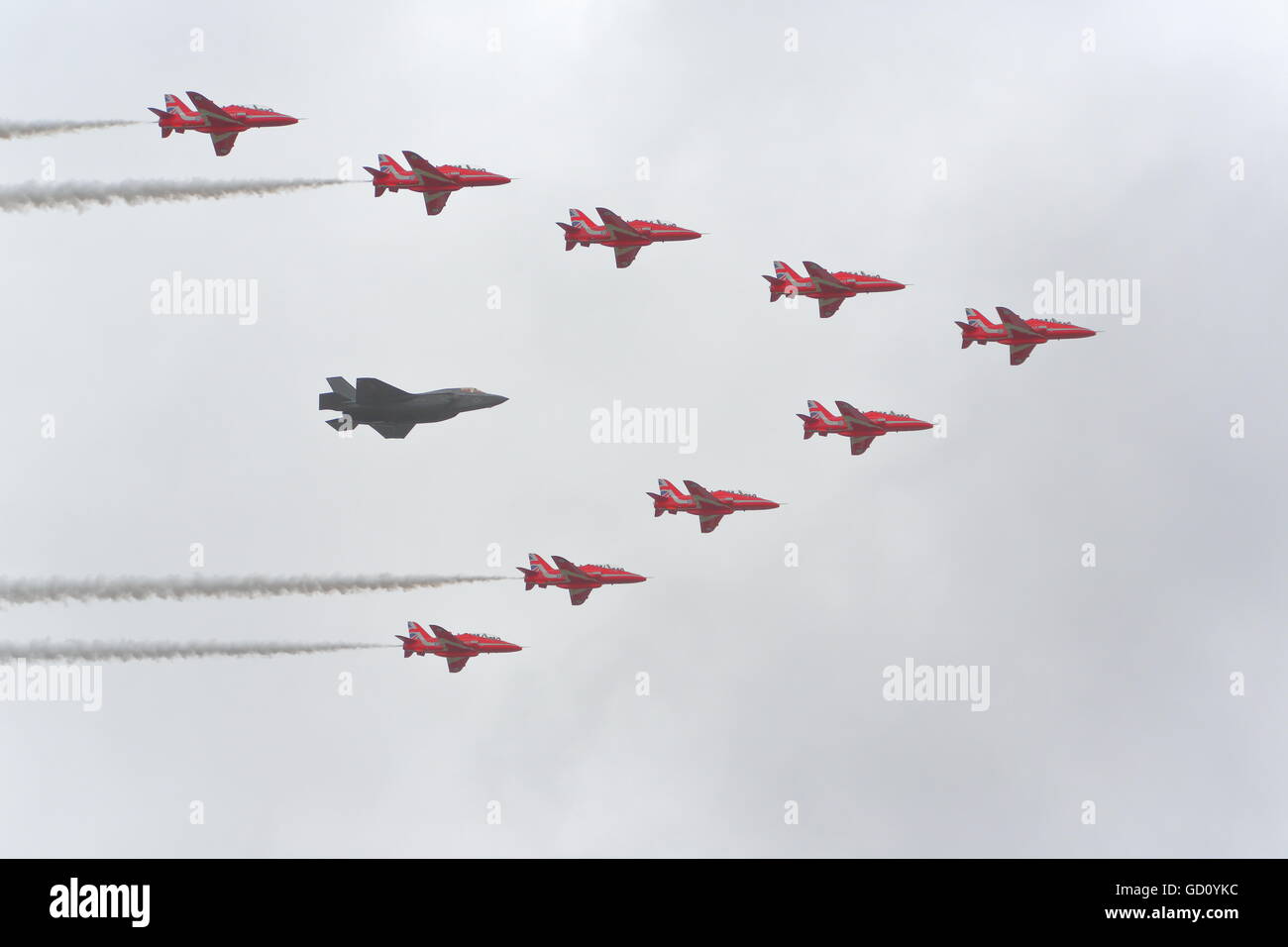 Farnborough, Hampshire, Regno Unito. 11 Luglio, 2016. Farnborough Airshow internazionale. Flypast di Lockheed Martin F35 accompagnato da frecce rosse Credito: Uwe Deffner/Alamy Live News Foto Stock