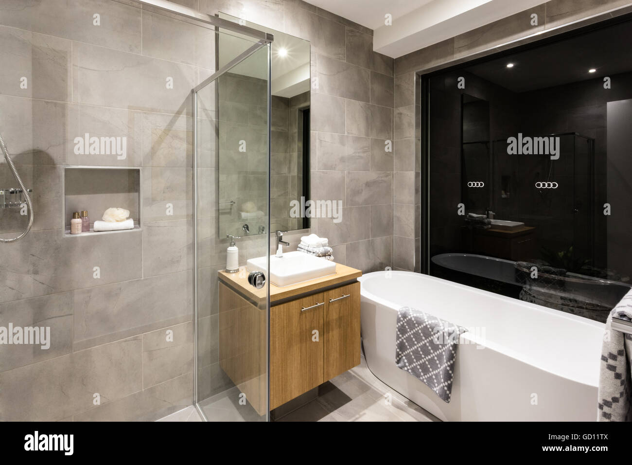 Bagno moderno con doccia e vasca da bagno accanto a uno specchio e ... Bagno moderno con vasca