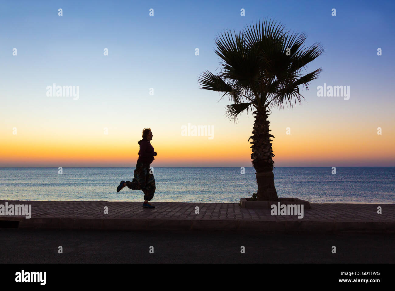 Giovane donna di jogging sul lungomare rendendo Fitness di mattina Foto Stock