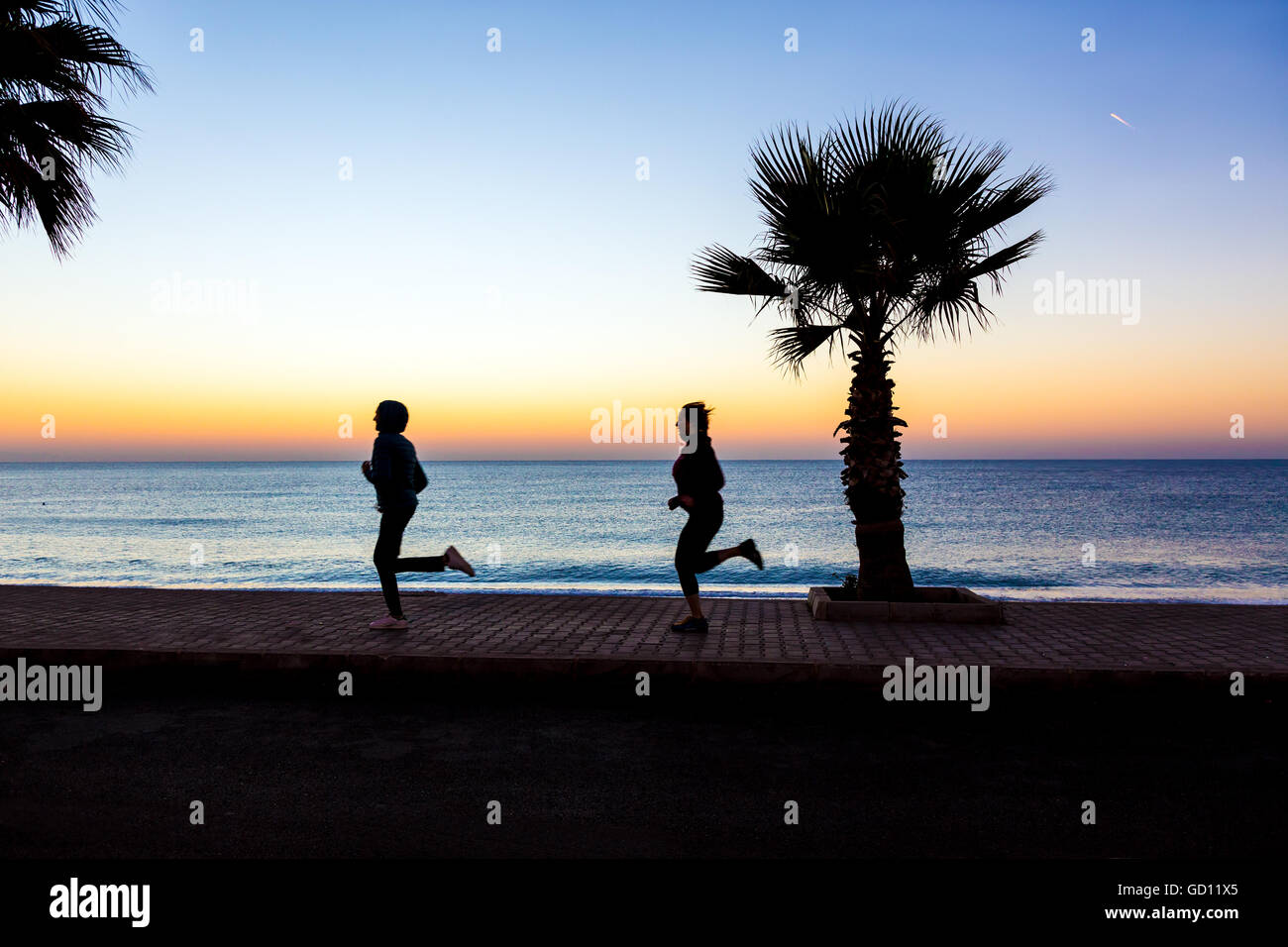 L uomo e la donna di jogging sul lungomare rendendo Fitness di mattina Foto Stock