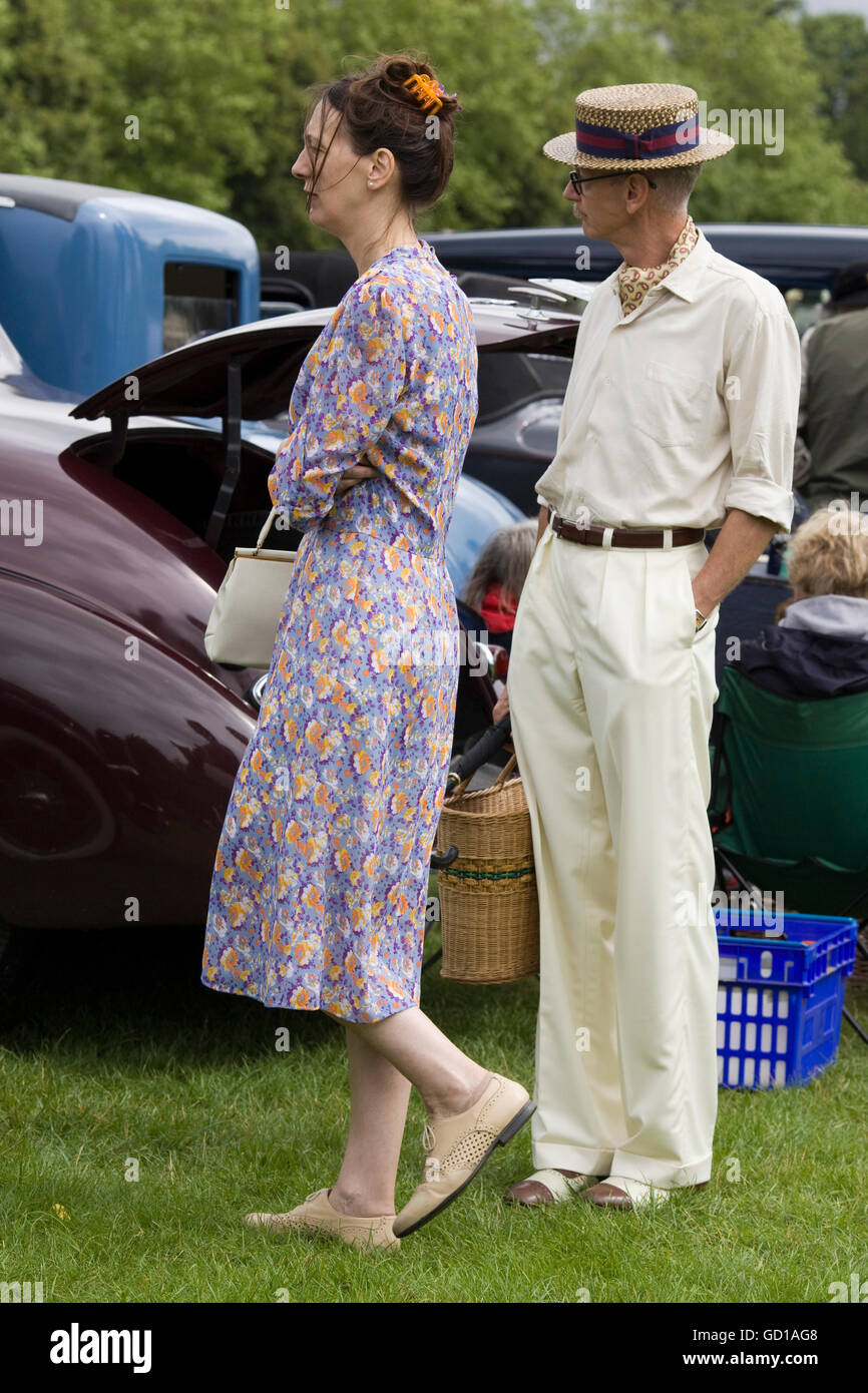 Uomo e donna che guarda la vintage American cars vestito di tradizione abbigliamento  retrò Foto stock - Alamy