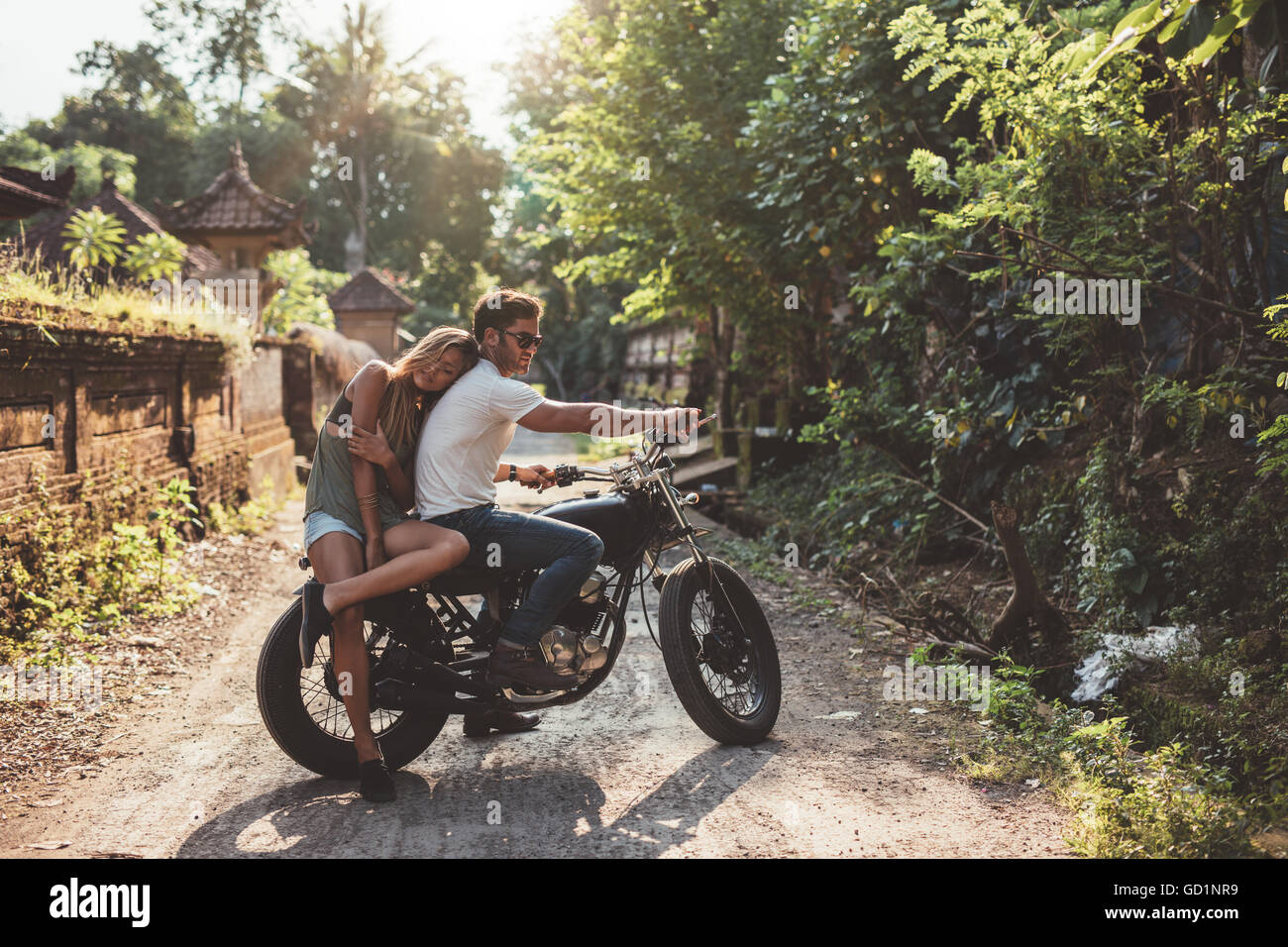 Amare giovane coppia in una motocicletta. Giovane uomo e donna in moto in un villaggio su un giorno d'estate. Foto Stock