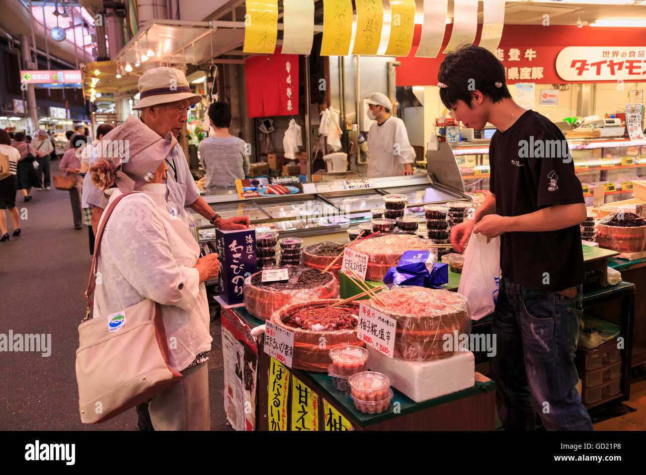 Agli acquirenti di effettuare l'acquisto presso Omicho cibi freschi di mercato, occupato e coperte colorate vie fiancheggiate da stalle, Kanazawa, Giappone, Asia Foto Stock