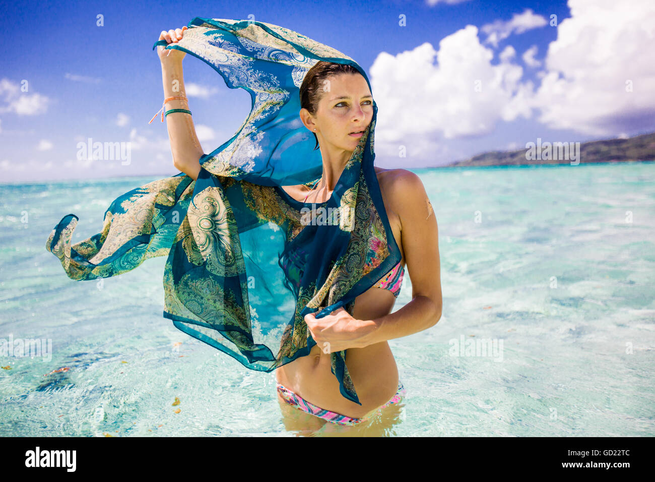 Donna in piedi in acqua, dimora Le Taha'a Resort, Tahiti, Polinesia francese, South Pacific Pacific Foto Stock