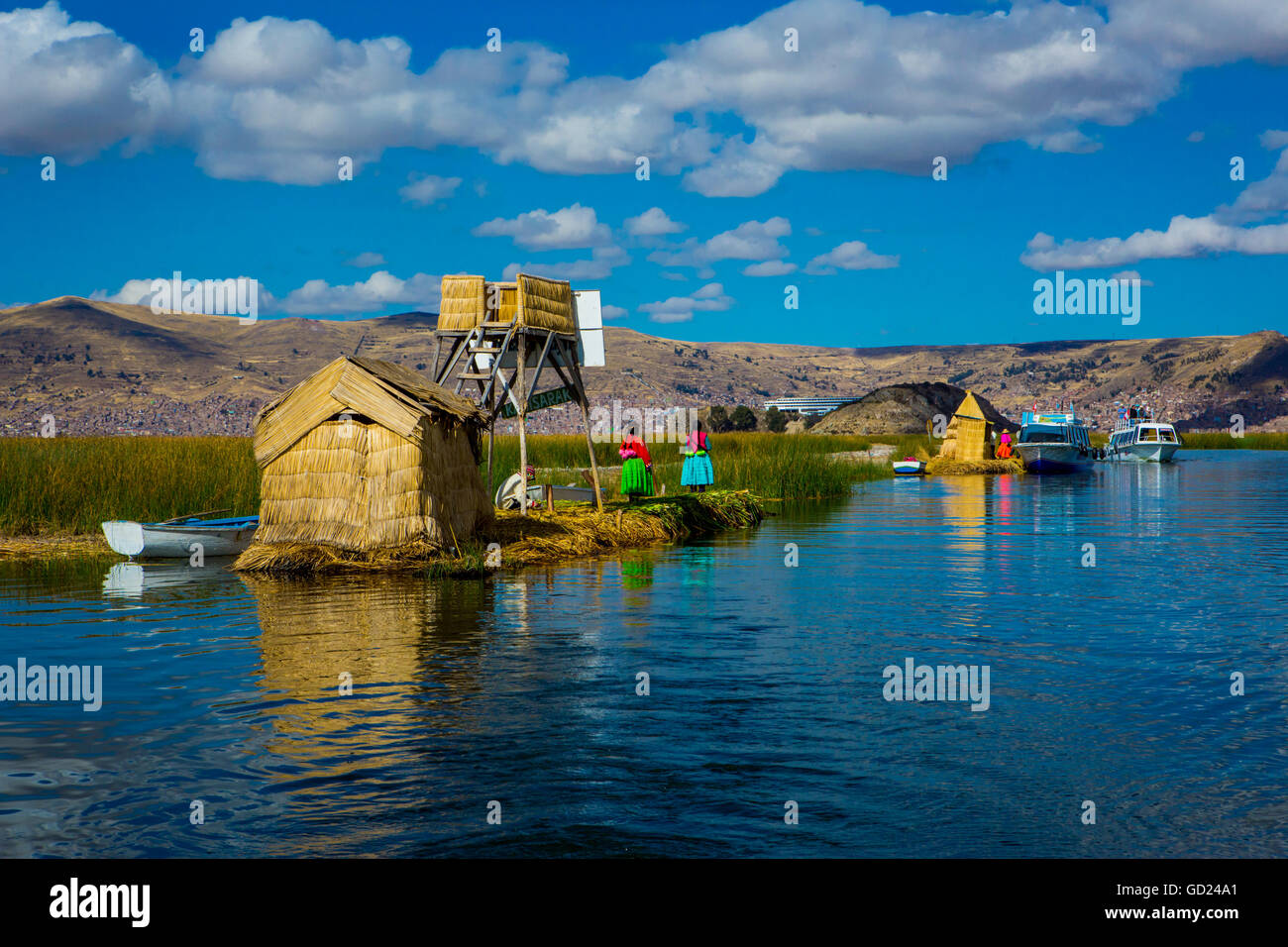 Il quechua famiglia indiana su erba flottante isole di Uros, il lago Titicaca, Perù, Sud America Foto Stock