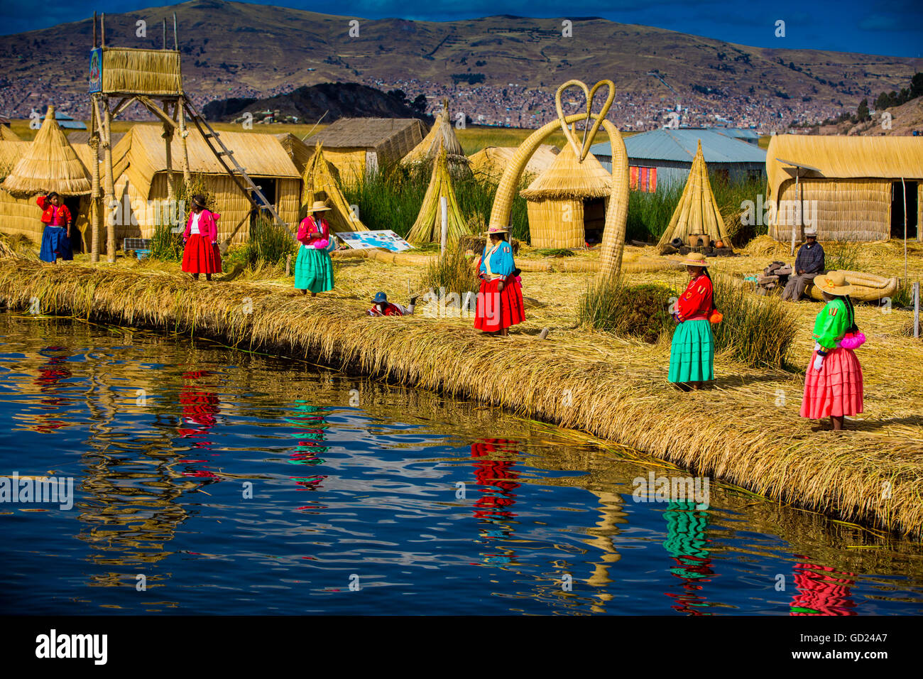 Il quechua famiglia indiana su erba flottante isole di Uros, il lago Titicaca, Perù, Sud America Foto Stock