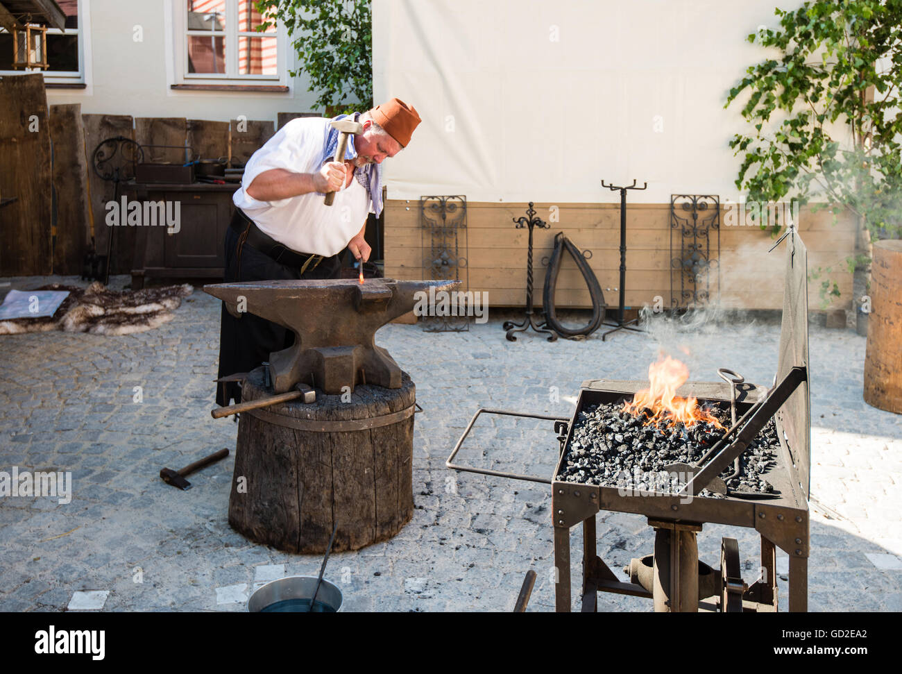 Un fabbro vestito in costume medievale lavora in una fucina. Forge all'aria  aperta durante la storia vivente festival Foto stock - Alamy