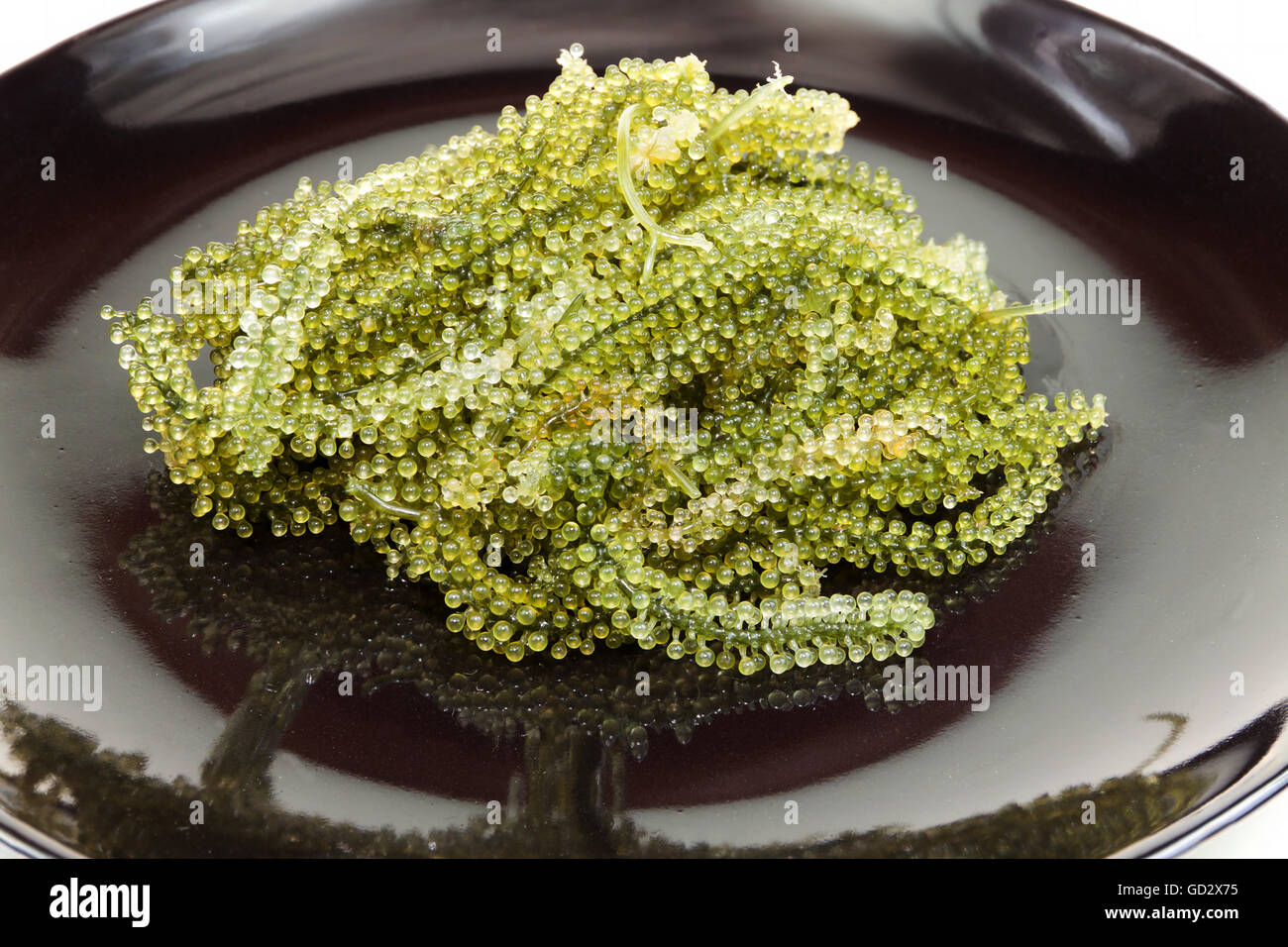 Mare di uve o di caviale verde su un piatto nero Foto Stock