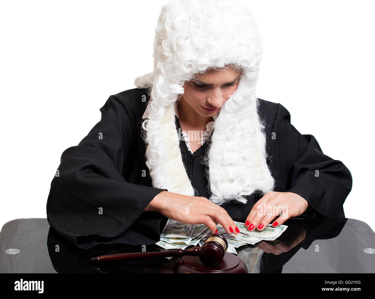 Femmina giudice corrotto conteggiare denaro al tavolo isolato su bianco Foto Stock