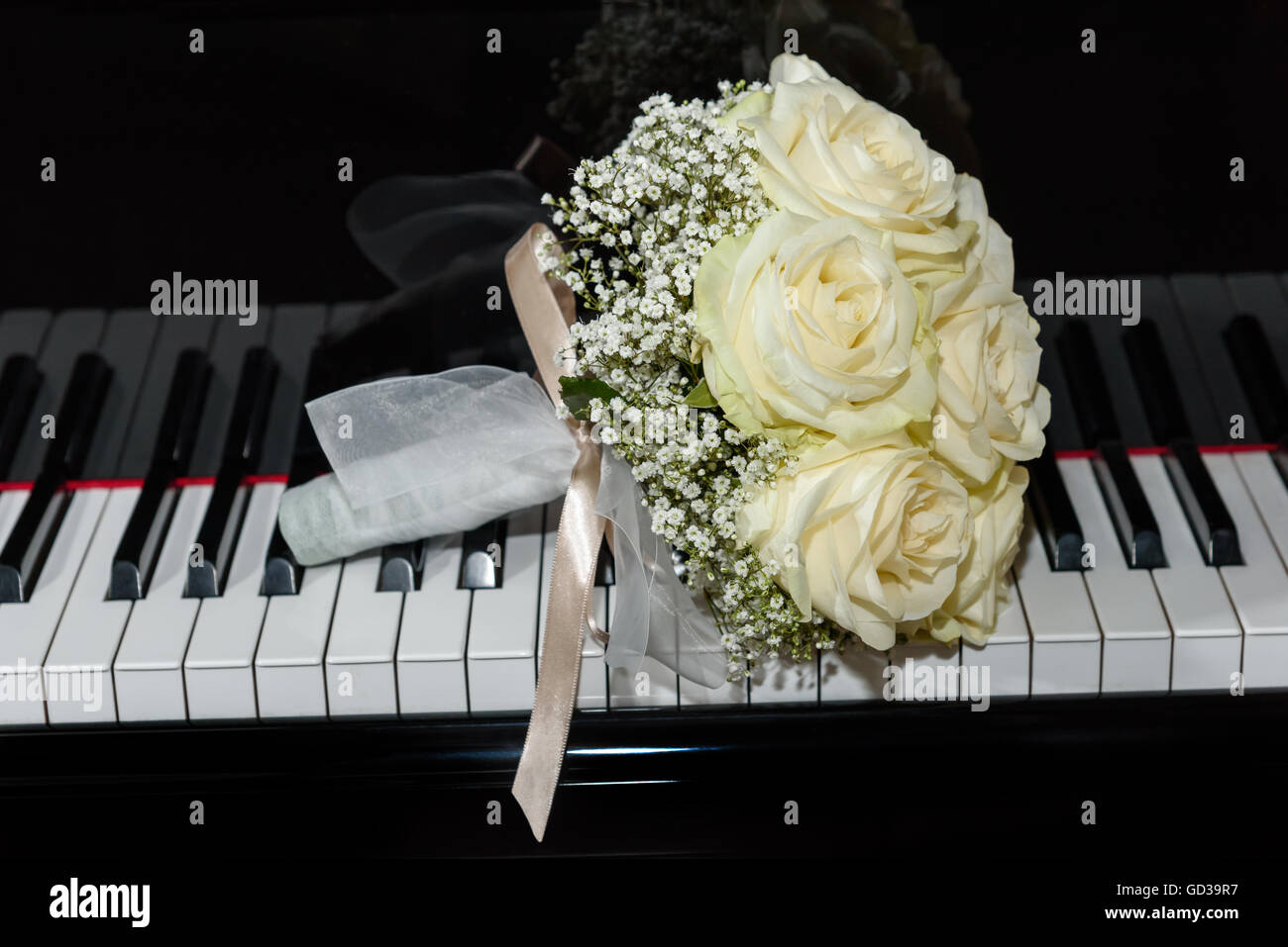 Mazzo di rose su una tastiera di pianoforte Foto Stock