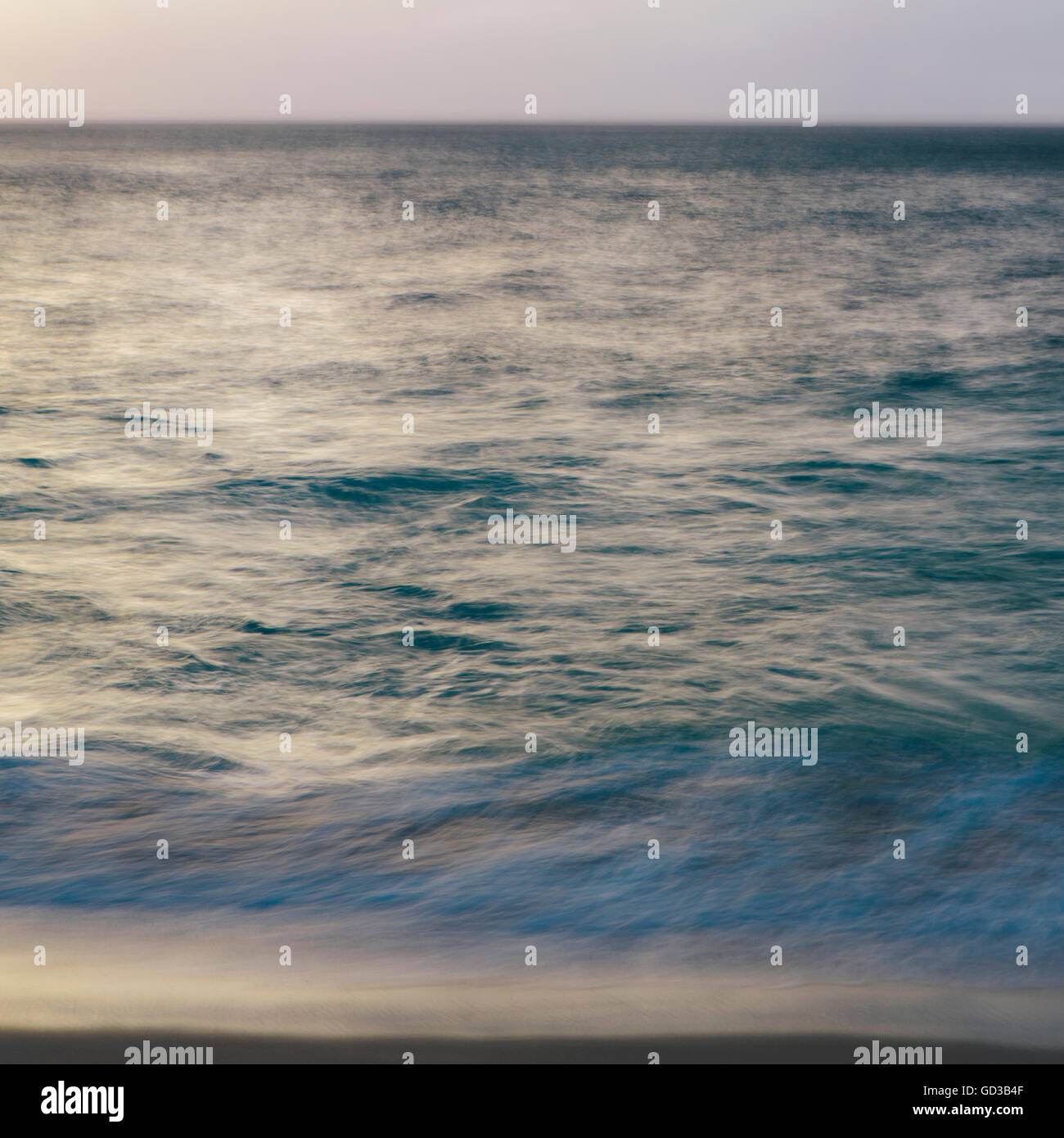 Le onde che si infrangono e la superficie dell'acqua all'alba. Foto Stock