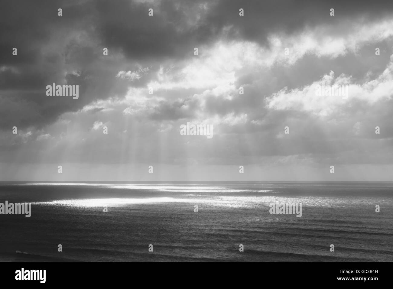 La luce del sole attraverso le nuvole sopra l'oceano Foto Stock