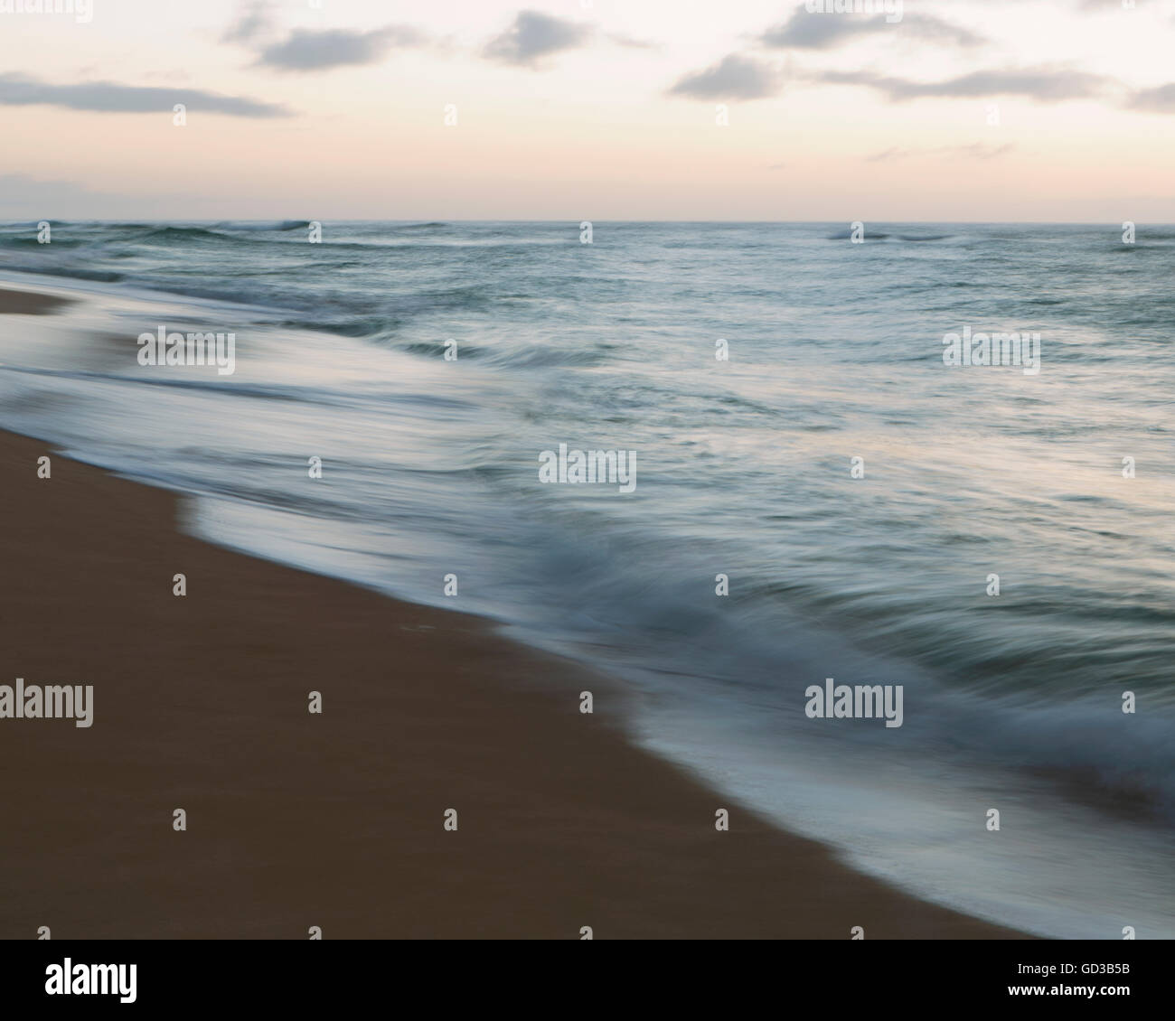 Seascape e onde che si infrangono sulla spiaggia al tramonto. Foto Stock