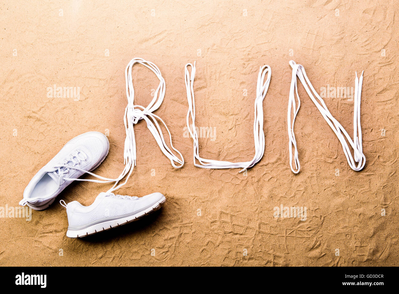 Scarpe da corsa e di eseguire il segno fatto di lacci delle scarpe, sabbia Foto Stock