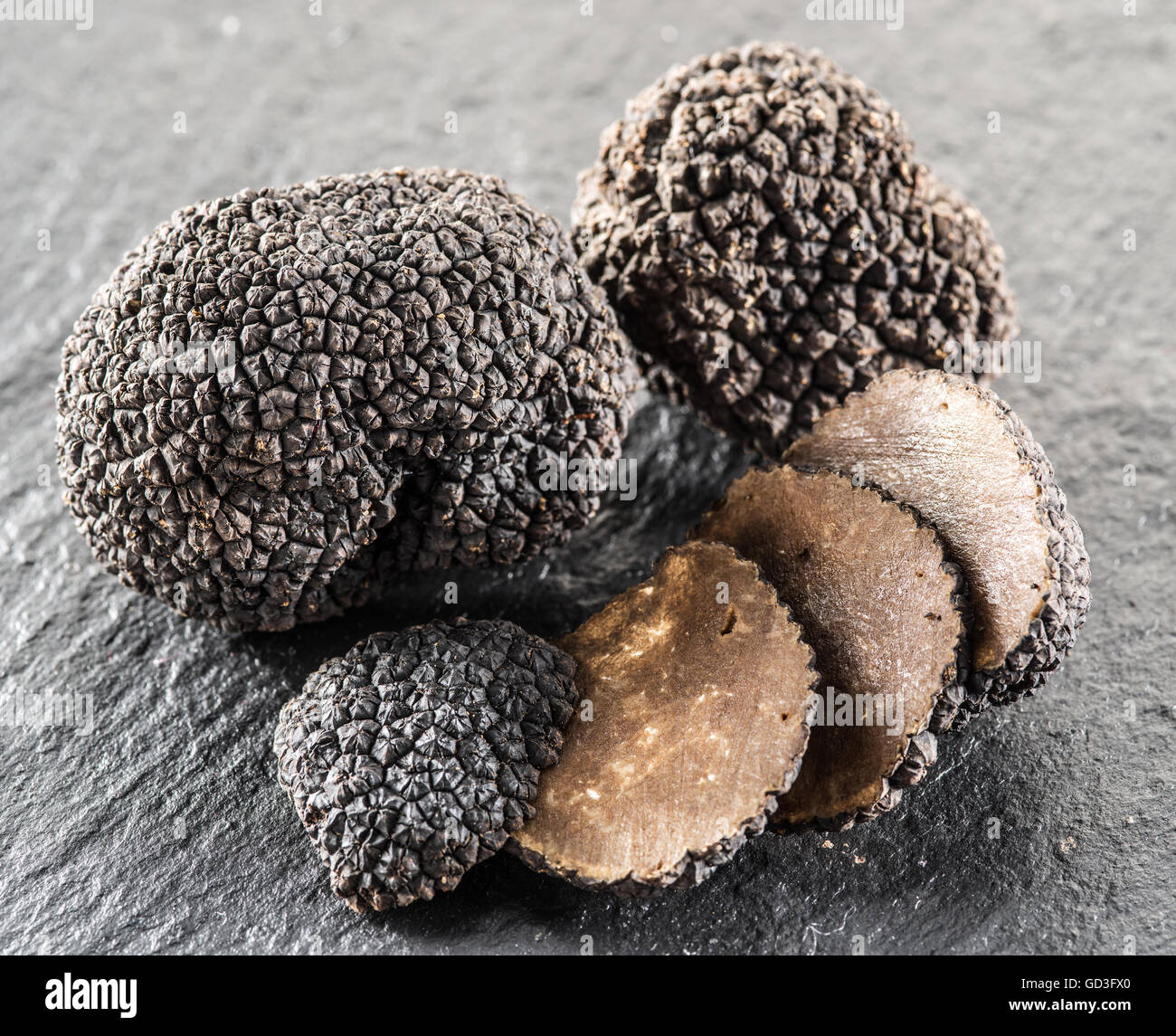 Tartufo nero e fettine di tartufo sulla scheda di grafite. Foto Stock