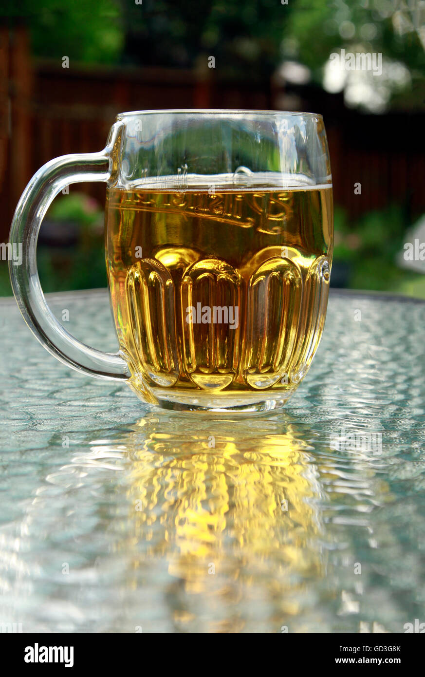 Un boccale di birra con birra ambrata su un tavolo di vetro Foto Stock