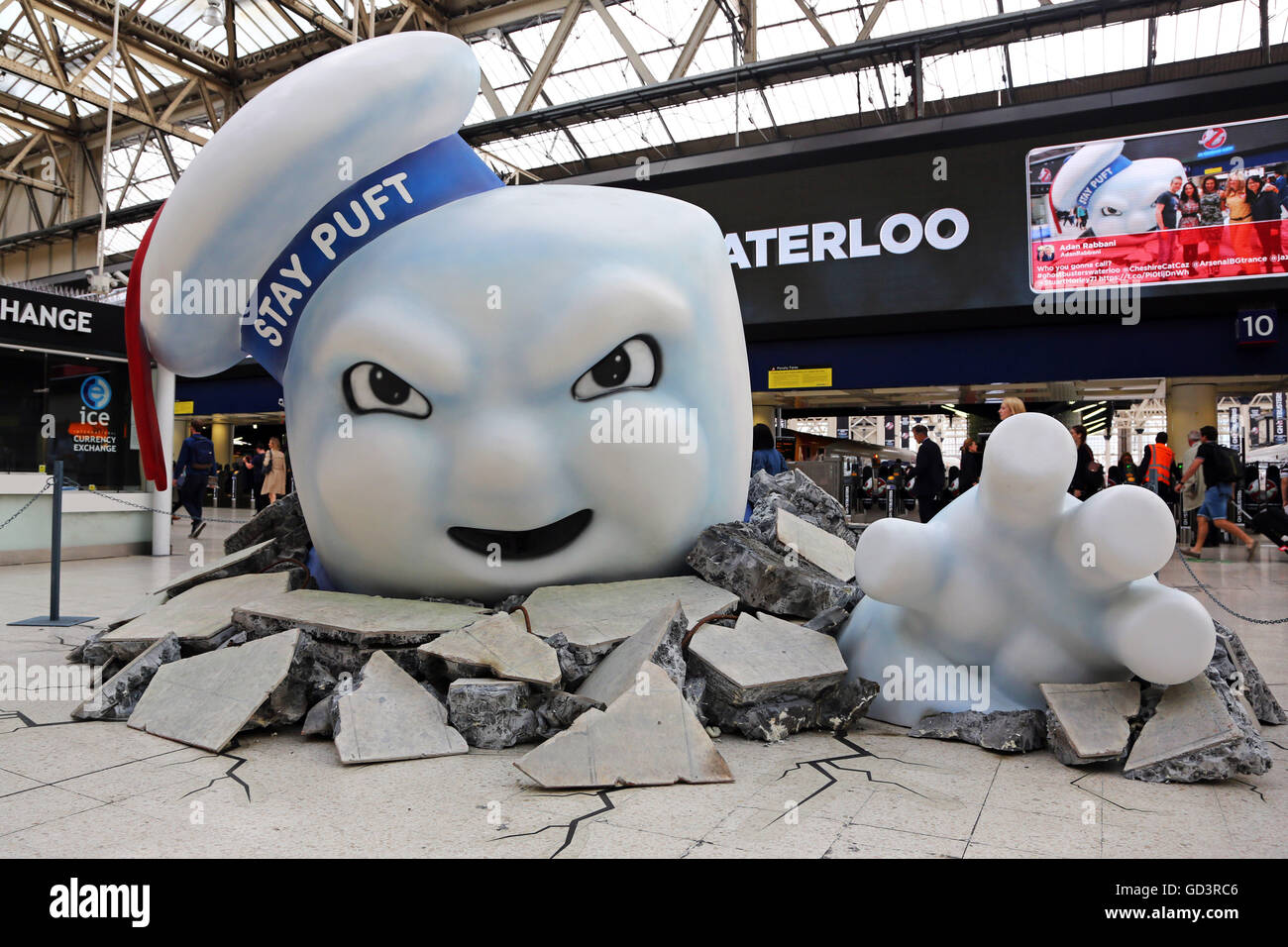 Il gigante di Marshmallow Man di Ghostbusters è visto la rottura attraverso il pavimento della stazione Waterloo di Londra come la pubblicità Foto Stock