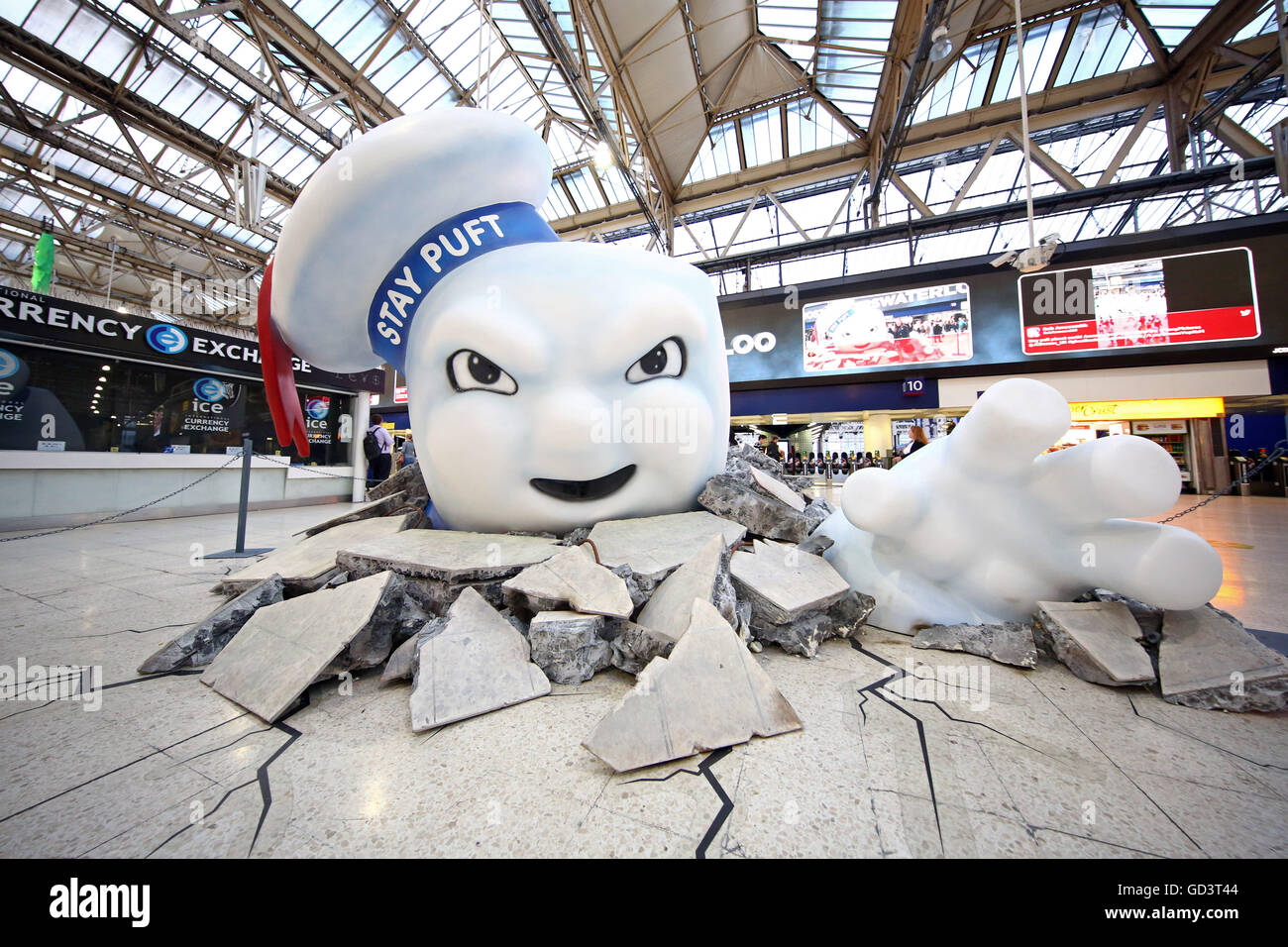 Il gigante di Marshmallow Man di Ghostbusters è visto la rottura attraverso il pavimento della stazione Waterloo di Londra come la pubblicità Foto Stock