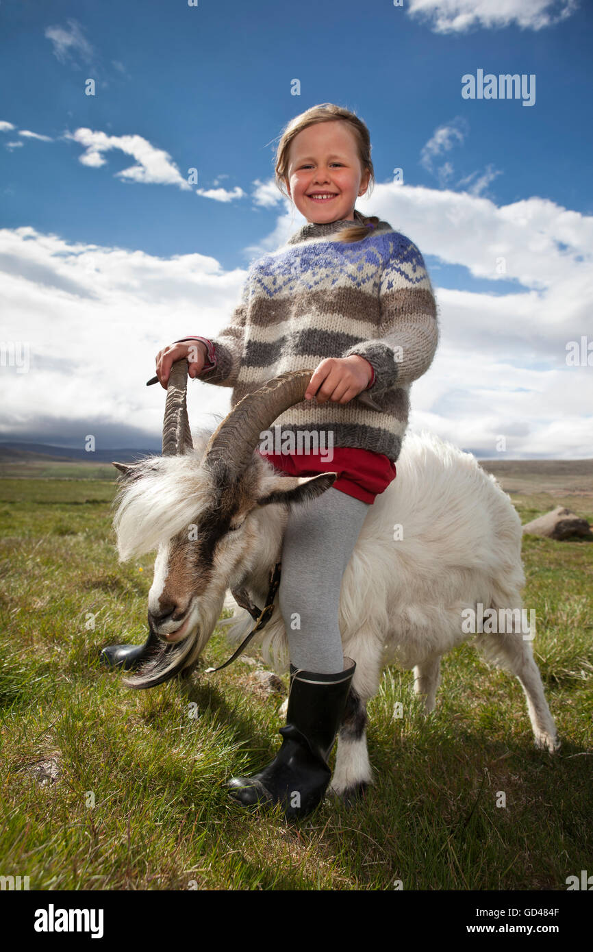 Ragazza seduta su di una capra, Western Islanda Foto Stock