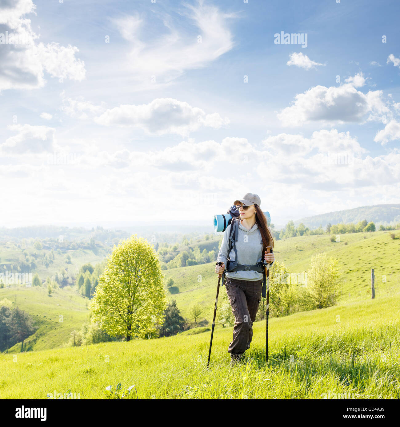 Giovane donna trekking con zaino in cima alla collina. Avventura backpacking sfondo con copia spazio e bella Foto Stock