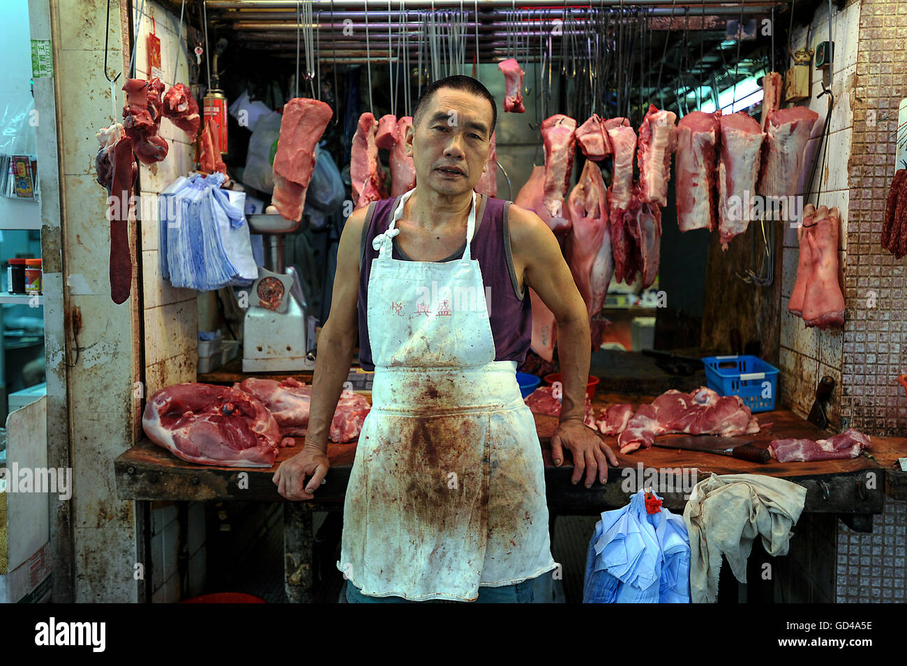 Cina, Hong Kong, 11 ottobre 2014. Un macellaio sorge di fronte al suo negozio di macellaio in Hong Kong. Foto Stock