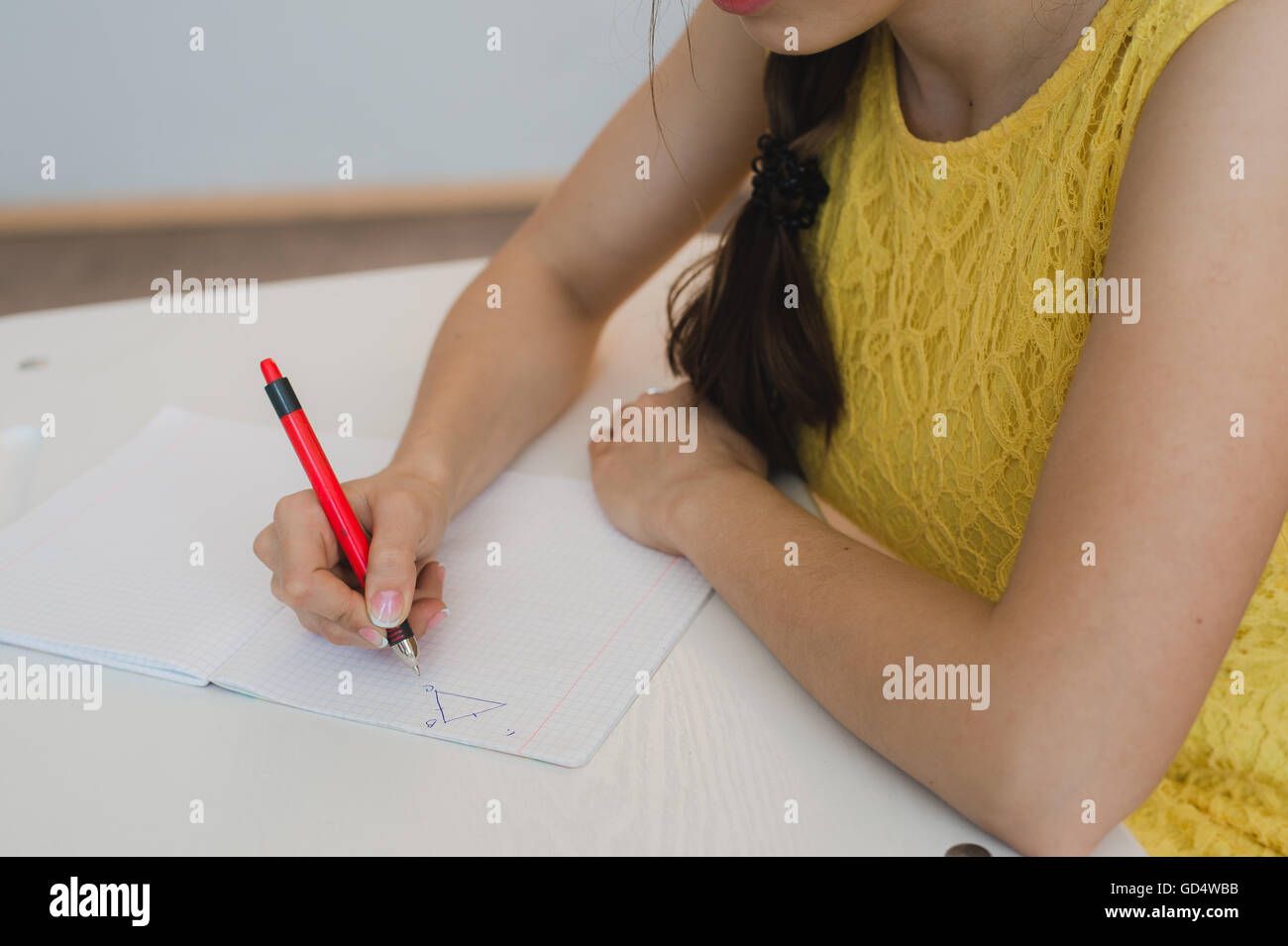 Stretta di mano della ragazza con la penna facendo matematica, triangolo di disegno Foto Stock