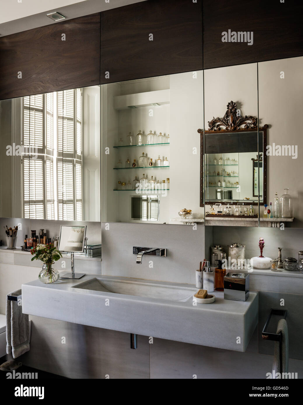 Chic moderno bagno con legno intagliato specchio rettangolare e lavabo Foto Stock