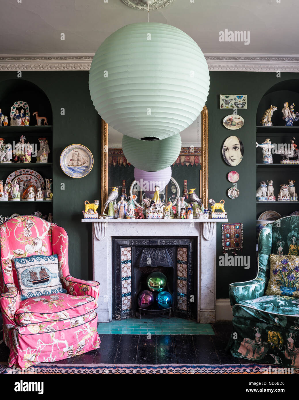 Disegno eclettico stanza dipinta in verde Sherwood da Farrow & Ball. Piastre Fornasettie, Stafforshire figure e pezzi Foto Stock
