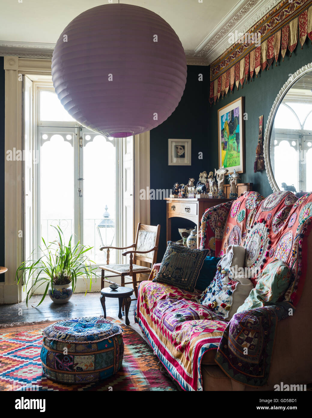 Stile giacobino Divano alto coperto di ricamo indiano, applique e una stampa Brunschwig in Regency sala da disegno con un kilim Foto Stock