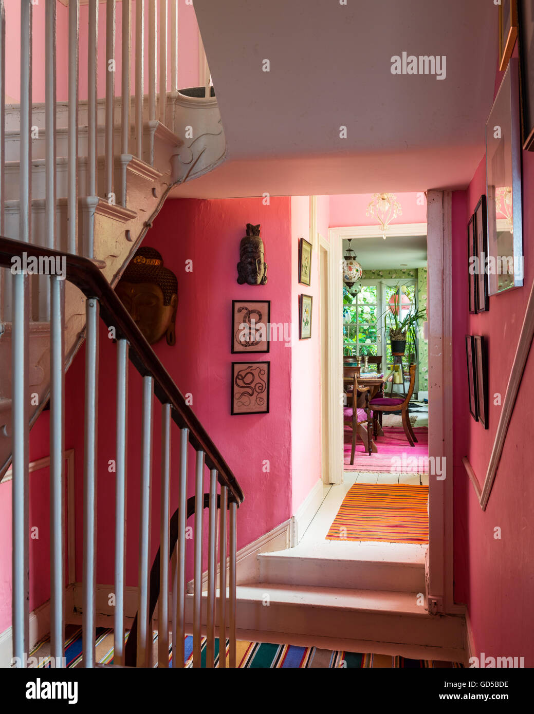 La tromba delle scale di colore rosa con vista guardando attraverso la sala da pranzo e giardino al di là Foto Stock