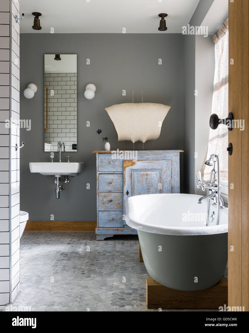 Free standing bath in bagno con personalizzate in armadio da opere di Boemia e pavimentazione a nido d'ape Foto Stock