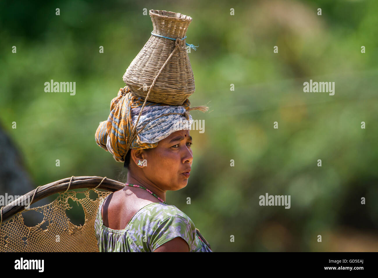 Donna di Tharu nel terai nepalese indossando abiti tradizionali per andare a pesca Foto Stock