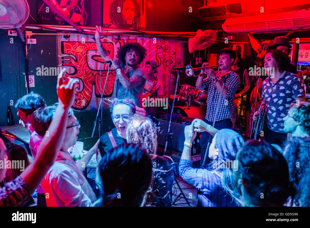 Folla godendo di musica suonata dal vivo di una band sul palco in Chiang Mai Thailandia Foto Stock
