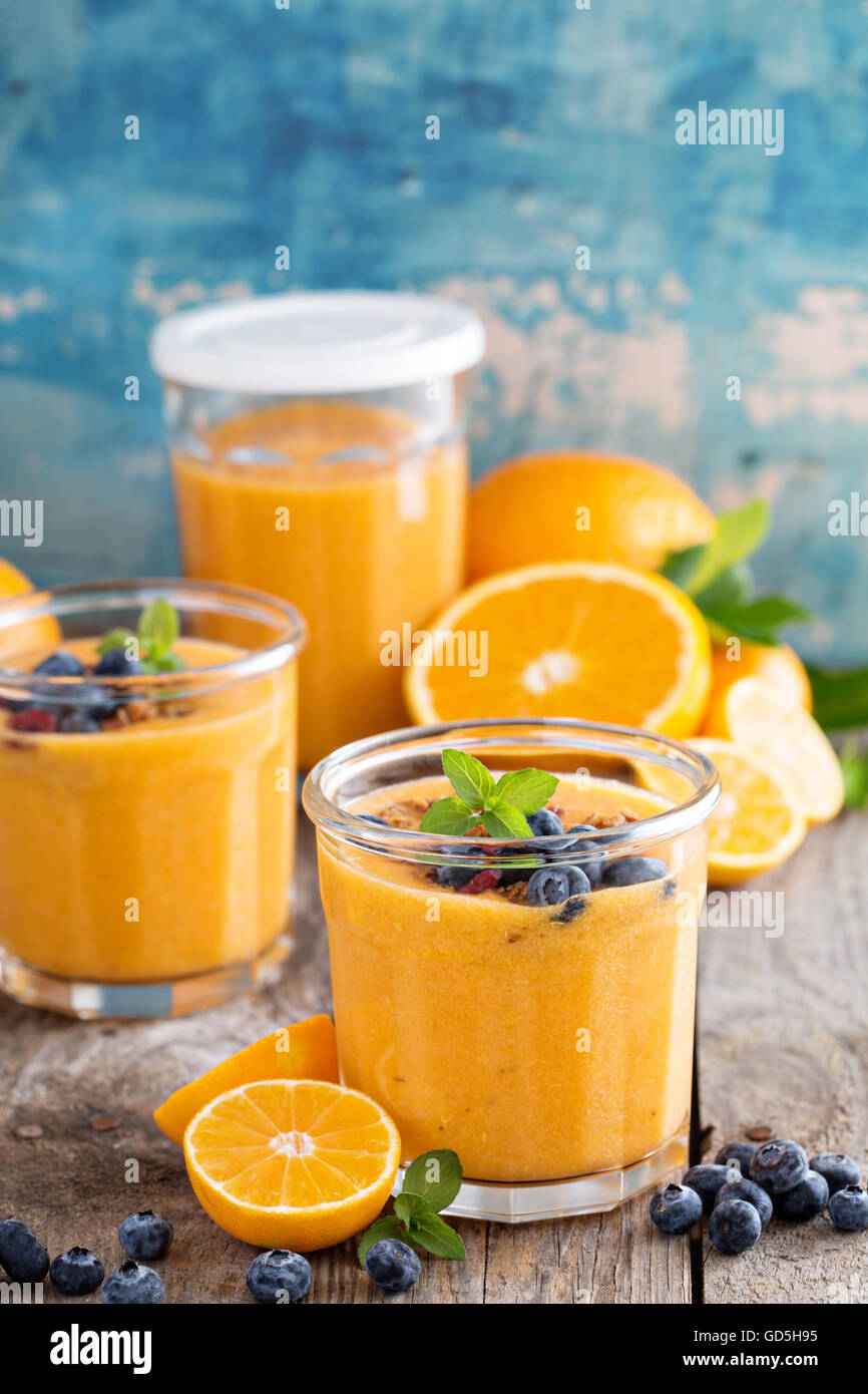 Arancione e mango smoothie con granola Foto Stock