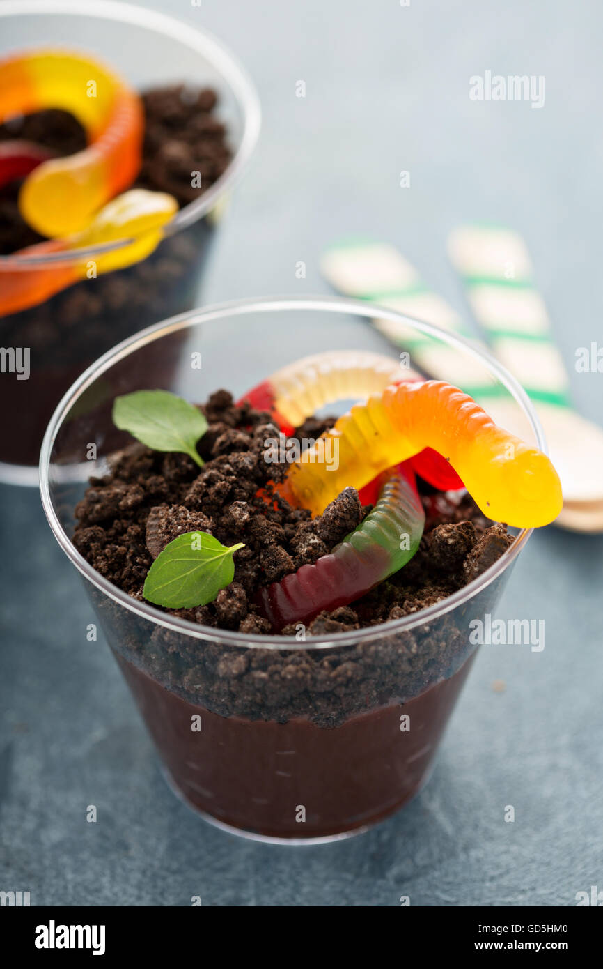 Bambini dessert al cioccolato in un bicchiere sporco e worm Foto Stock