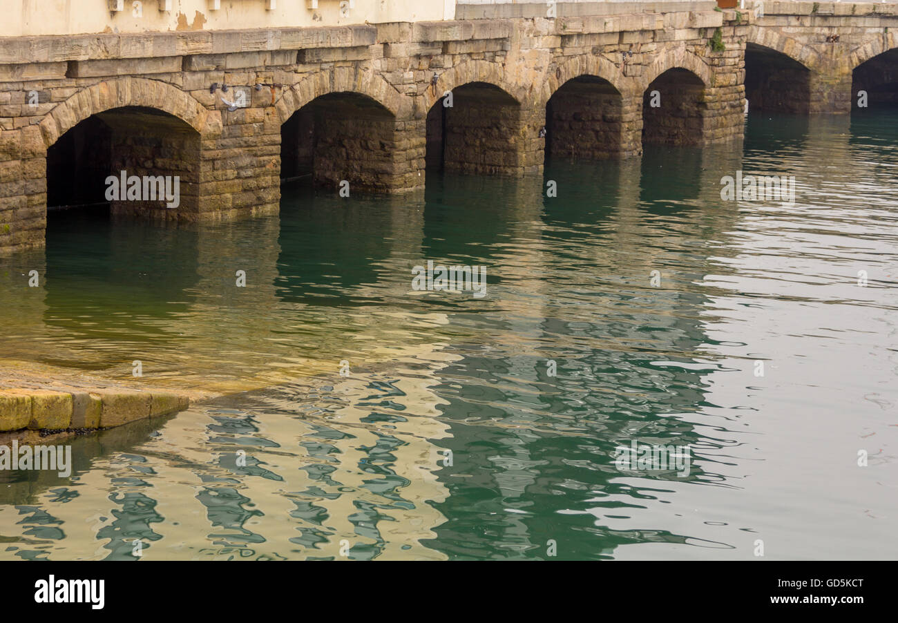 Antiche arcate in pietra nel porto di Gijon, Spagna Foto Stock