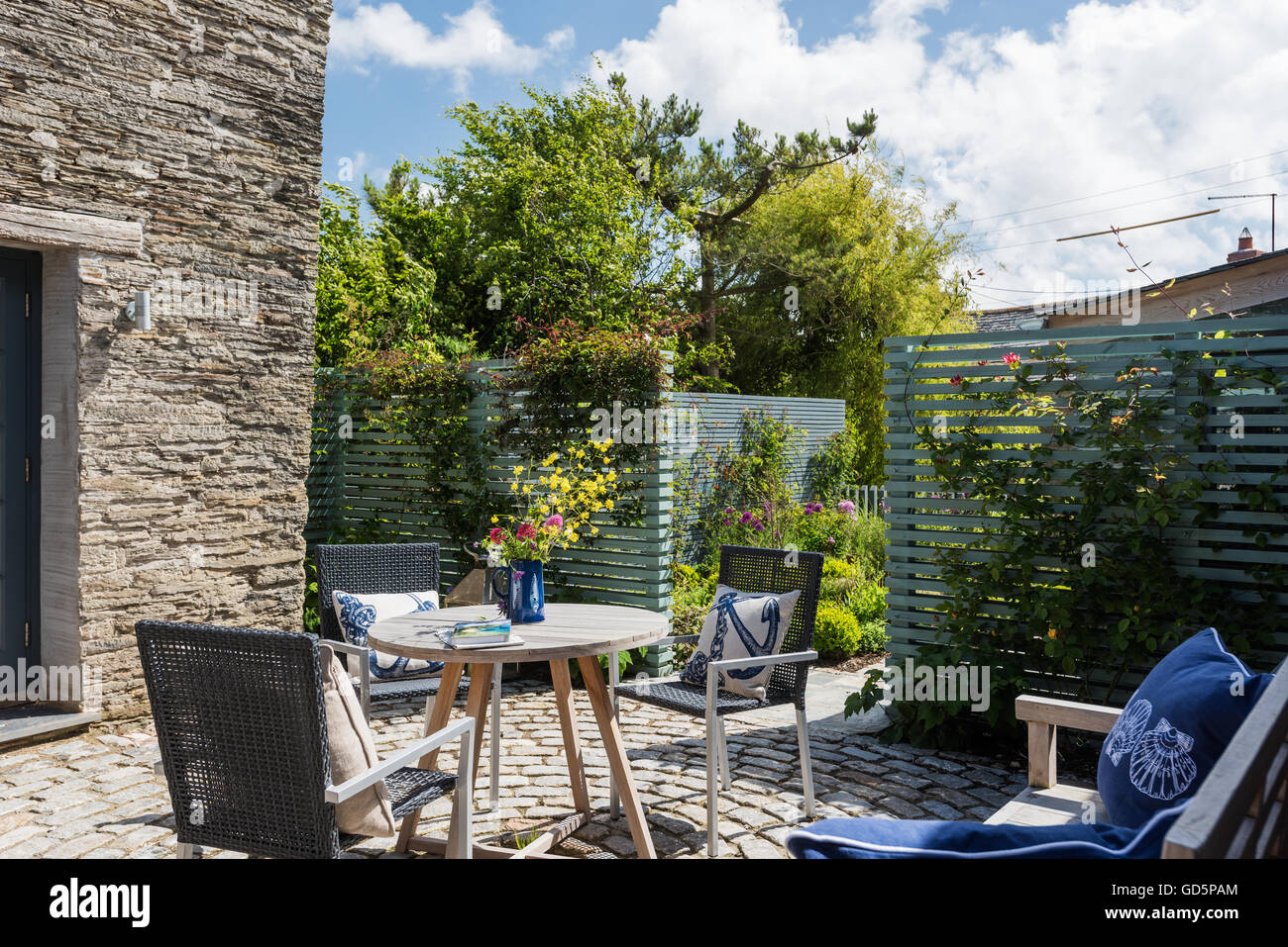 Mobili da giardino in cortile cottage con mattoni circolare lastricatore patio Foto Stock