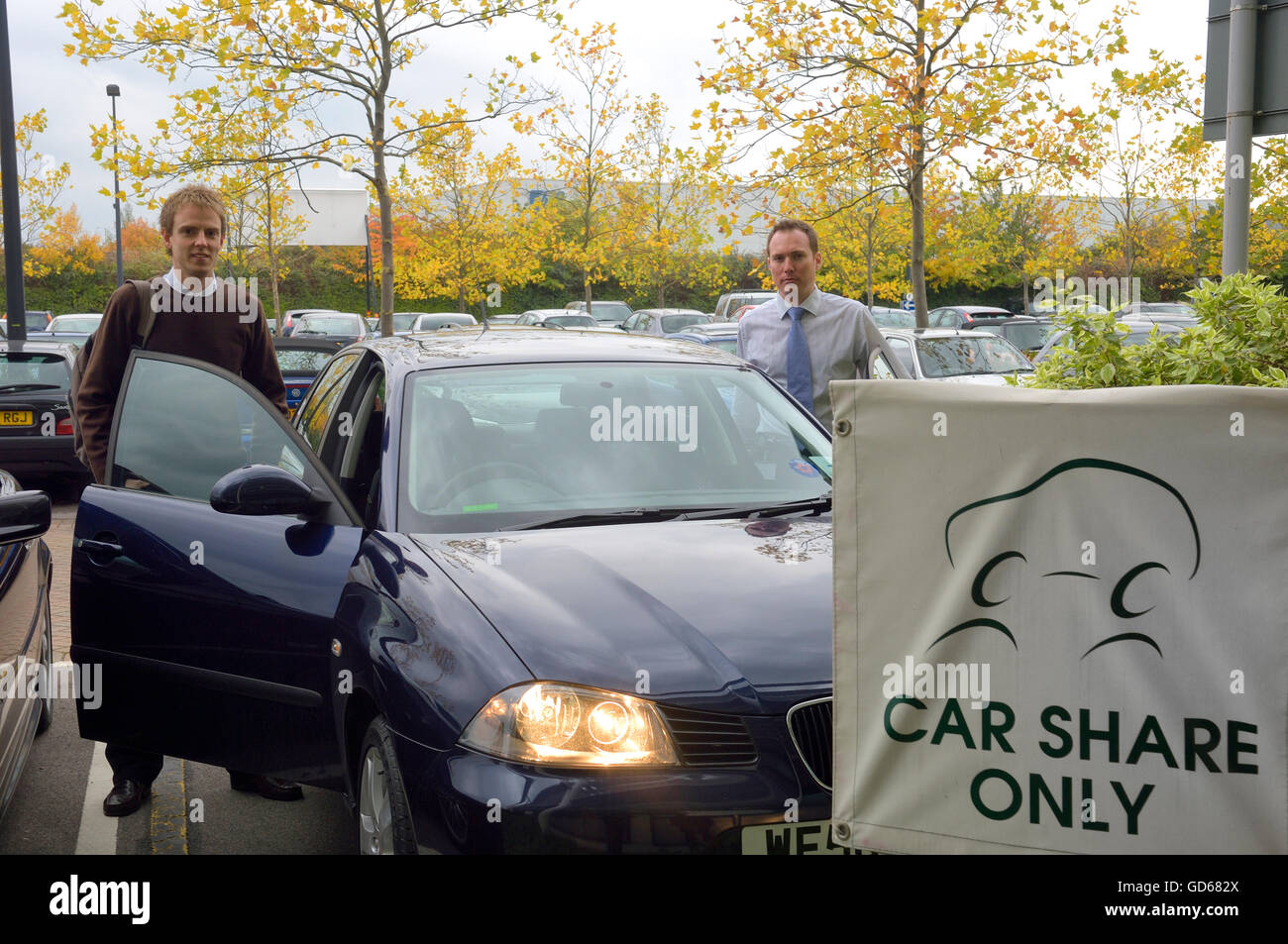 Due auto partecipi per arrivare in auto al loro posto di lavoro parcheggio auto. In Inghilterra. Regno Unito. Foto Stock