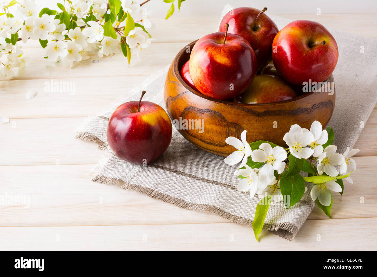 Mele fresche nella ciotola di legno e Apple Blossom. Frutti maturi come mangiare sano o cibo vegetariano concetto. Foto Stock