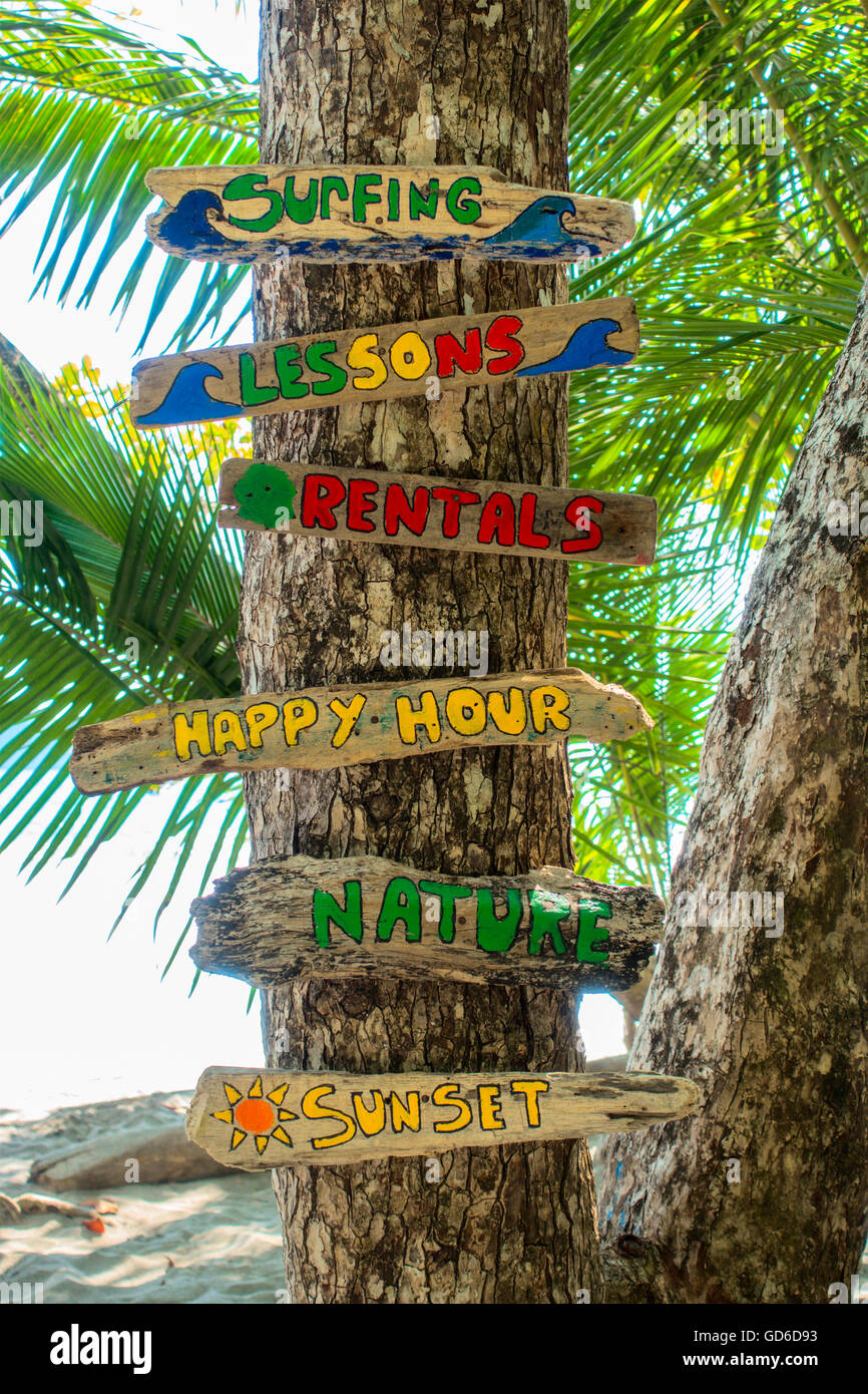Segni colorati pubblicità lezioni di surf. Playa Espadilla, Quepos, Puntarenas Provincia, Costa Rica, l'America centrale. Foto Stock