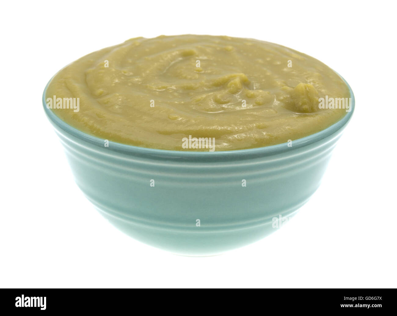 Una ciotola di verde spessa zuppa di piselli quasi traboccante isolato su uno sfondo bianco. Foto Stock