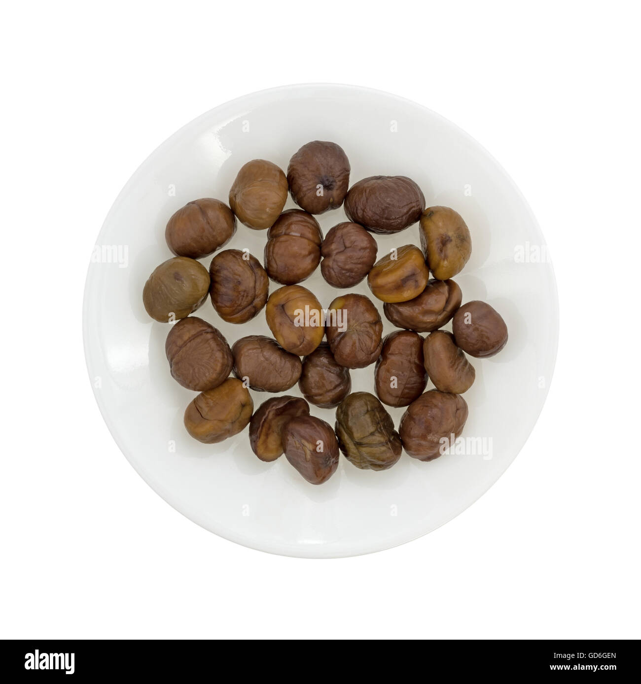 Vista in pianta di una piastra con organici intere sgusciate castagne arrostite isolato su uno sfondo bianco. Foto Stock