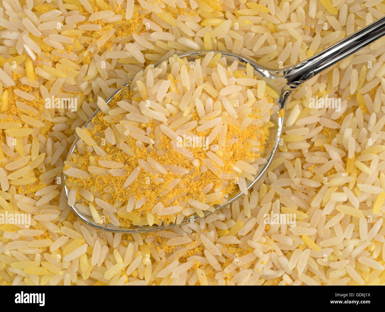 Vista ravvicinata di zafferano riso e condimenti su un cucchiaio in cima più cibo. Foto Stock