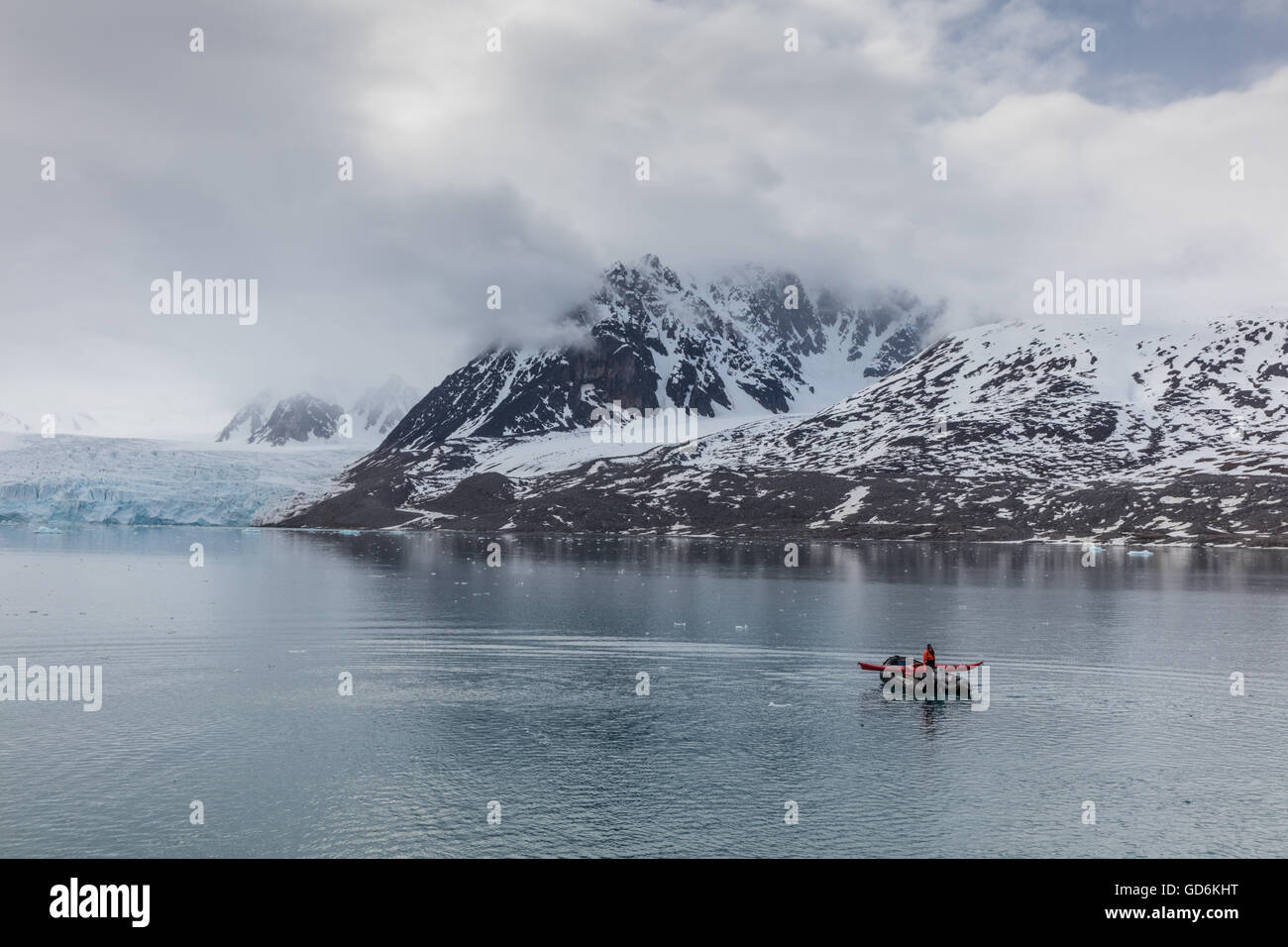 Lone zattera gonfiabile in Liefdefjorden, arcipelago delle Svalbard, Norvegia. Monacobreen (Monaco glacier) è visibile dietro. Foto Stock