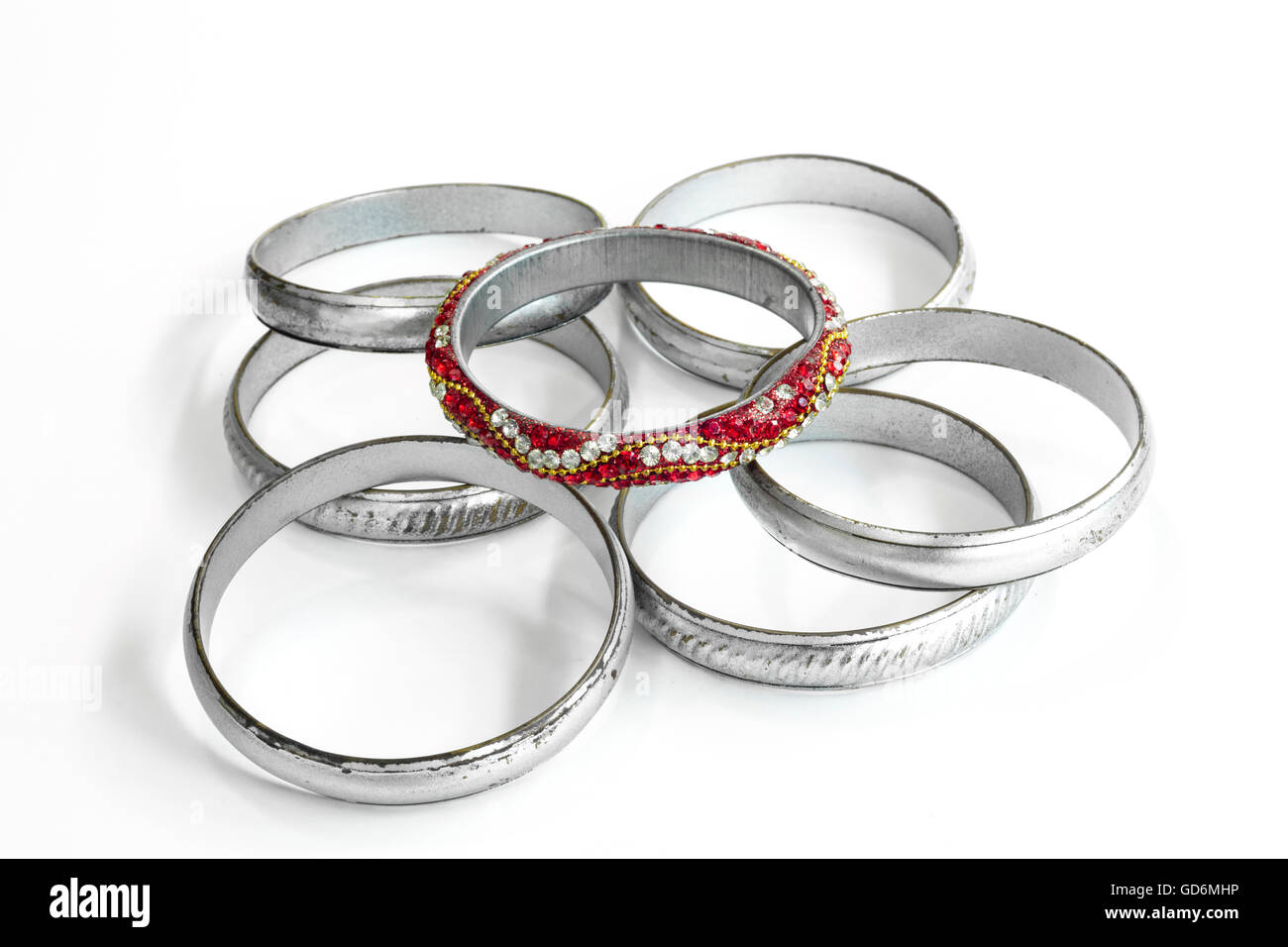 Gruppo di bracciali in argento e una molto diversa composta dai colori rosso e gemme, in contrasto con gli altri Foto Stock